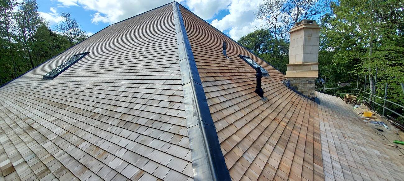 Cedar shingle roof with skylights and stone chimney